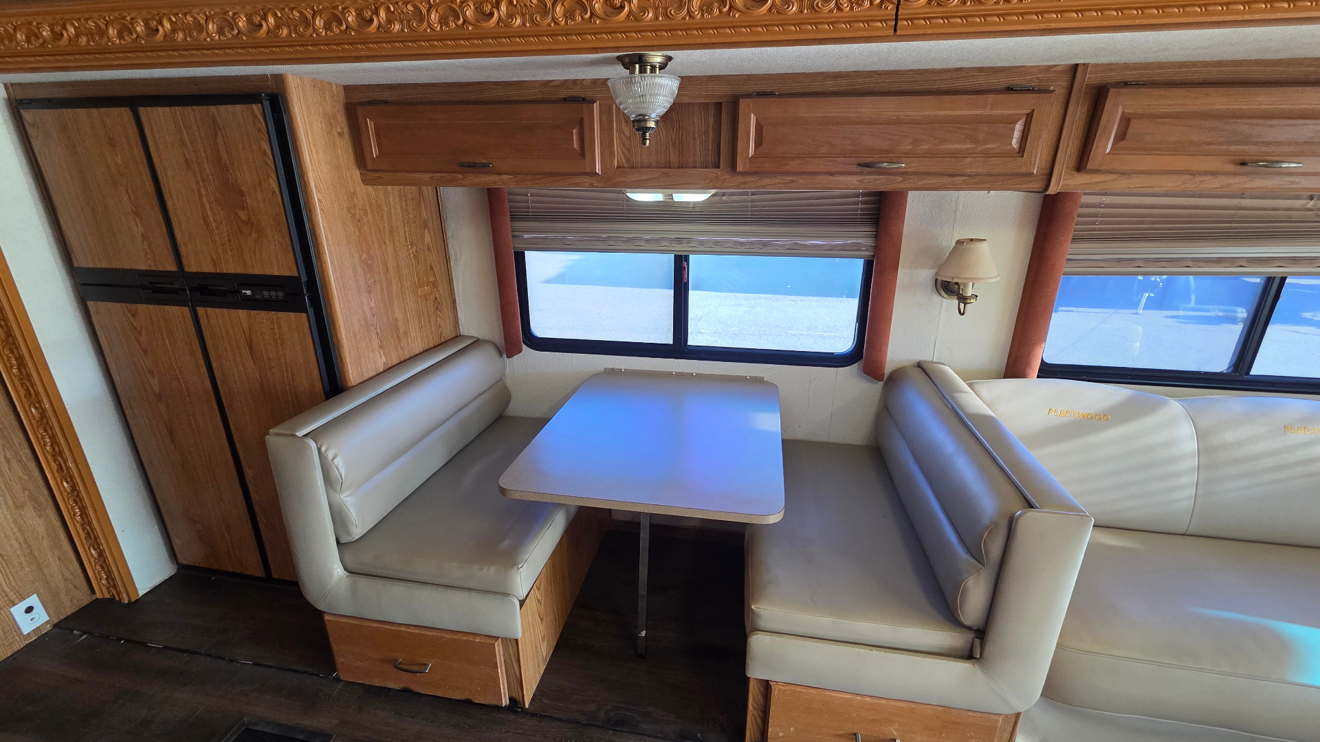 2005 Fleetwood Bounder 35E — dinette booth beside sofa and refrigerator