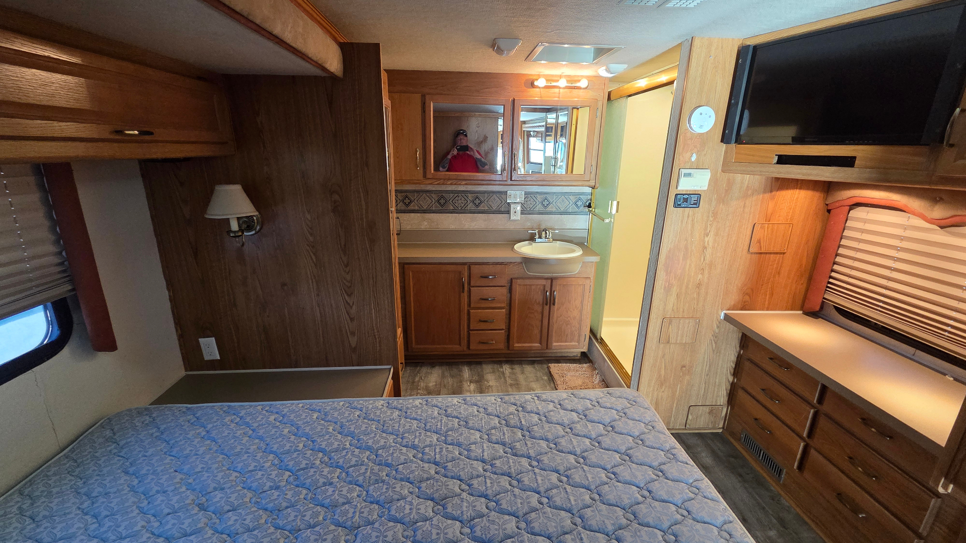 2005 Fleetwood Bounder 35E — bedroom looking toward split bath vanity and TV